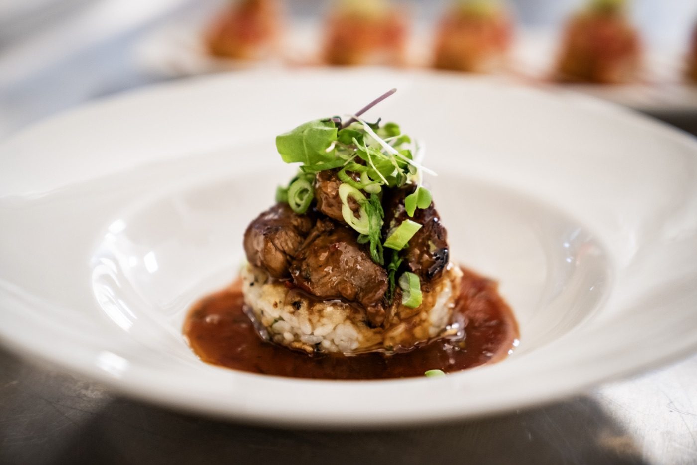 Korean-style filet at Little Alley Steak Alpharetta — seared filet medallions over herbed rice in a savory pan sauce, finished with scallions and micro greens